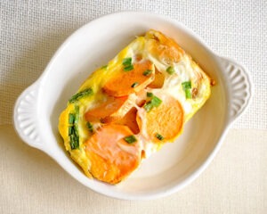 round plate with baked eggs and sweet potato